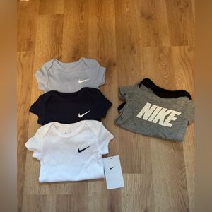 Set of four nike onesies- size 6 months NWT and one is used. Boy or girl